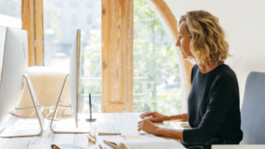 A woman sitting at her desk in a well-lit space