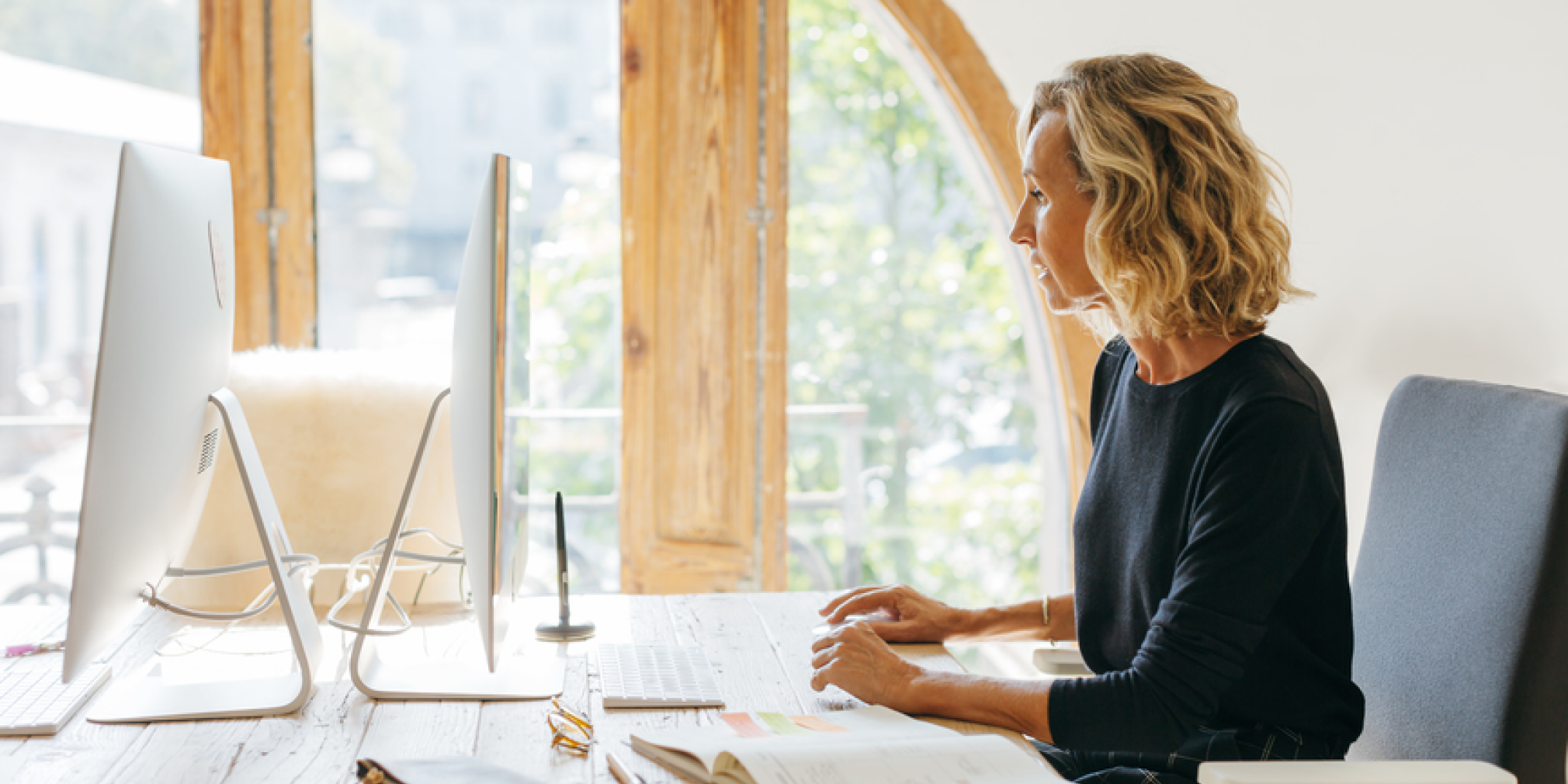 A woman sitting at her desk in a well-lit space