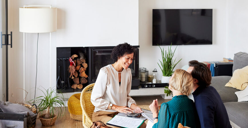 a couple meeting with a financial advisor in their living room