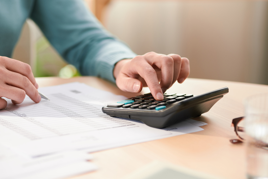 a business owner using an old-fashioned calculator for their business accounting
