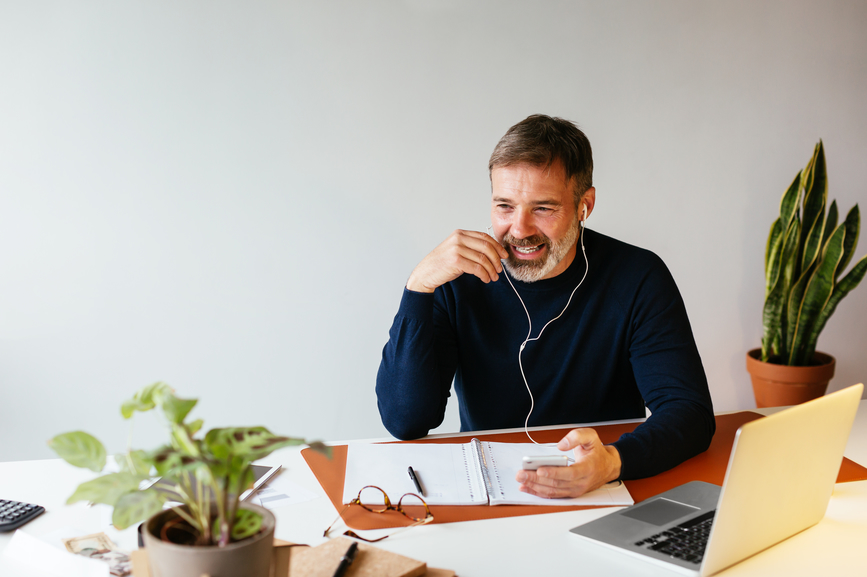 A man taking a phone call at a desk