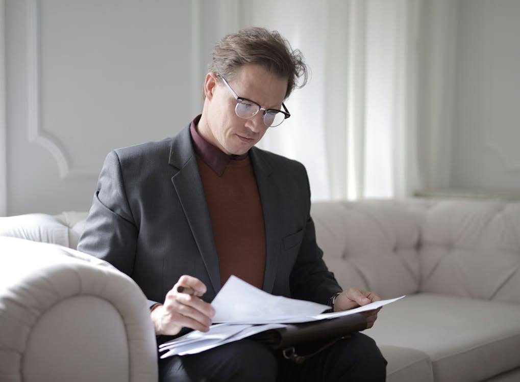 A man in a gray suit reading documents