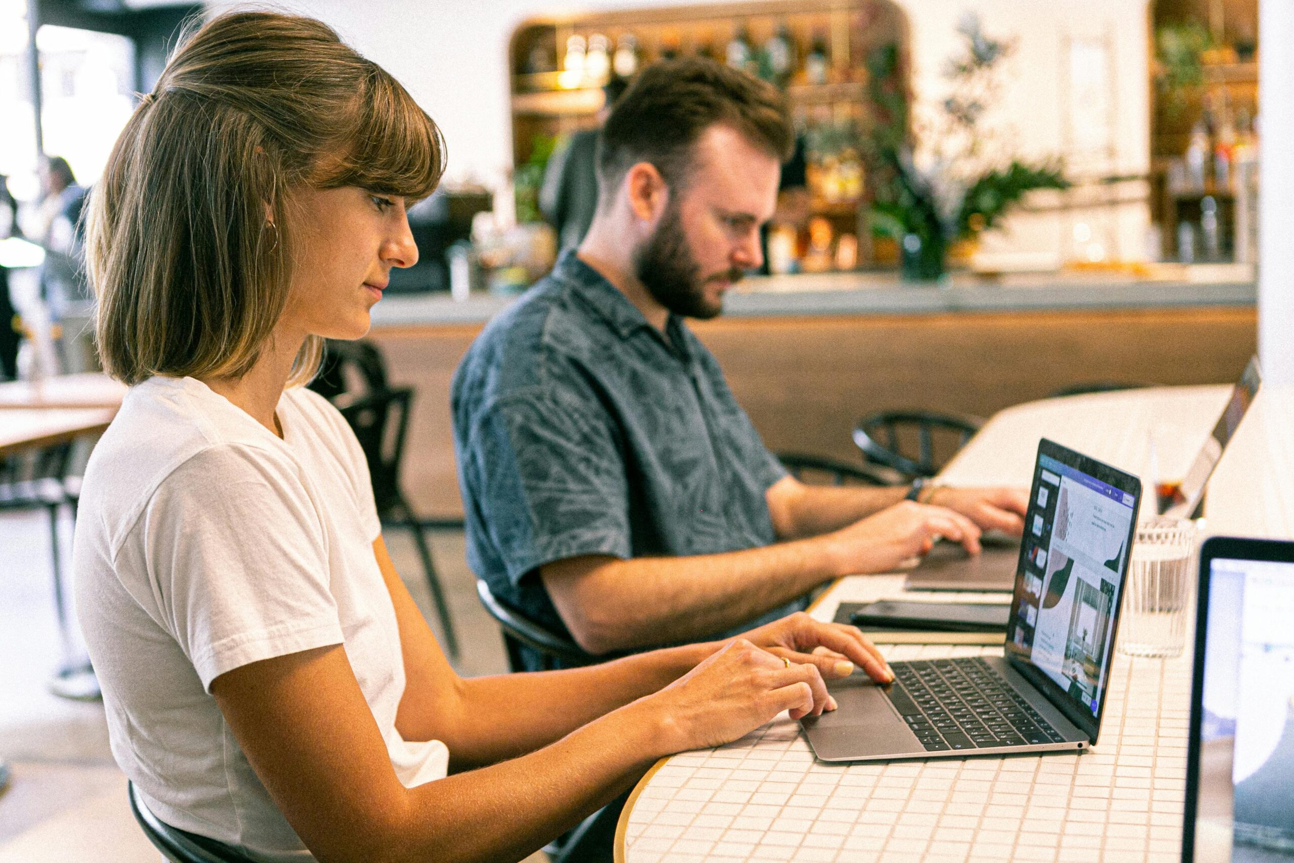 two young professionals working remotely in a coffee shop